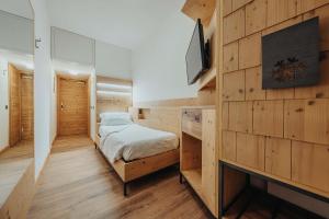 a bedroom with a bed and a desk at Hotel Olimpia in Cortina dʼAmpezzo