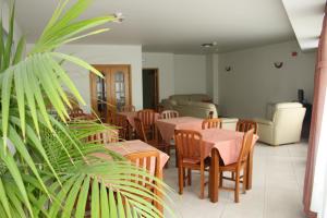 a restaurant with tables and chairs and a plant at Residencial Stª Joana in Aveiro