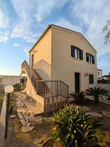 a house with a staircase in front of it at Bougainvillea in Marina di Modica