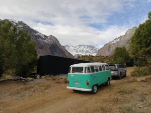 een groen en wit busje geparkeerd op een onverharde weg bij Refugio con vista al Volcán in Refugio Lo Valdés