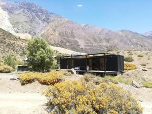 a black house in the middle of a mountain at Refugio con vista al Volcán in Lo Valdés