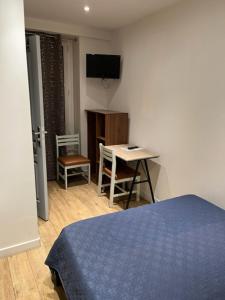 a bedroom with a bed and a table and a desk at Hotel Luna Park in Paris