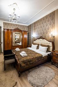 Un dormitorio con una cama grande y una lámpara de araña. en Classic Royal central apartment. Balcony and A/C, en Leópolis