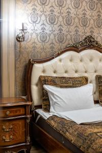 Una cama con una almohada blanca junto a un tocador en Classic Royal central apartment. Balcony and A/C, en Leópolis