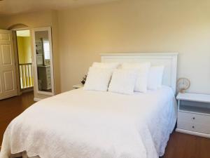 1 dormitorio con cama blanca y almohadas blancas en Balloons and Wine en Murrieta