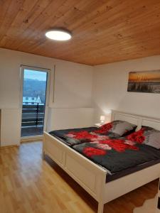 Un dormitorio con una cama con flores rojas. en Ferienwohnung Elena, en Zweibrücken