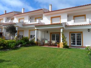 una casa con césped delante en Golf, Praia, Piscina, Ar Puro, en Amoreira