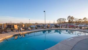 une petite piscine avec des chaises et une clôture dans l'établissement Best Western Dothan Inn & Suites, à Dothan