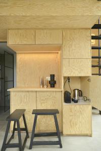een keuken met 2 krukken en een tafel en een aanrecht bij Le Studio du Designer in Libin