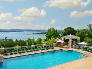 a swimming pool with chairs and a view of a lake at Chateau on the Lake Resort Spa and Convention Center in Branson