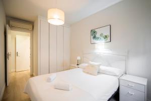 Un dormitorio blanco con una cama blanca y una lámpara en dobohomes - Francisco Santos, en Madrid