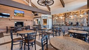 a restaurant with tables and chairs and a bar at Best Western Plus Silver Saddle Inn in Estes Park