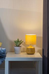 a lamp on a table with a plant on it at Dunes Hotel in Whitley Bay