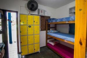 Habitación con taquillas amarillas y litera. en Farah Suítes e Passeio de barco en Boicucanga