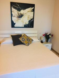 a bedroom with a bed with a flower painting on the wall at Appartamento alle Dune! Dalla piscina alla spiaggia in 30 mt! in Silvi Marina