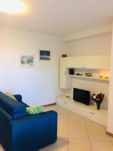 salon z niebieską kanapą i telewizorem w obiekcie Le Dune 65 Ginestra Silvi Marina w mieście Silvi Marina +34 zdjęcia