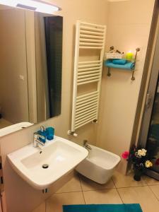 a white bathroom with a sink and a mirror at Appartamento alle Dune! Dalla piscina alla spiaggia in 30 mt! in Silvi Marina