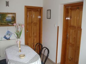 a table with a vase of flowers on it at Petrovics Apartmanház 1 in Bük