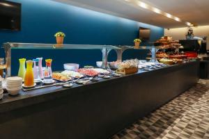 a kitchen counter filled with lots of food at Comfort Hotel Guarulhos Aeroporto in Guarulhos