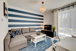 een woonkamer met een blauwe en witte streepmuur bij Apartamenty Na Fali - Morski , Błękity , Marynarski in Pobierowo