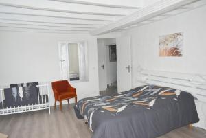 a white bedroom with a bed and a chair at Gîte LE LOGIS De La CHARNIE Confort pour 14 personnes à Chemiré-En-Charnie in Chemiré-en-Charnie