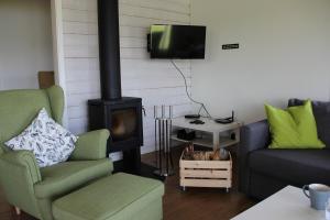 a living room with two chairs and a stove at Lakeview Houses Sweden in Falun