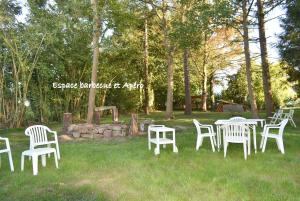 a group of white chairs and tables in the grass at Gîte LE LOGIS De La CHARNIE Confort pour 14 personnes à Chemiré-En-Charnie in Chemiré-en-Charnie