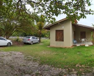 a small house with two cars parked in front of it at Chalé em Algodões, Villa Cajú in Barcelos do Sul +8 photos