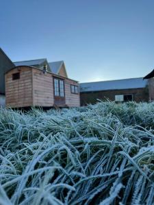 a large pile of grass in front of a house at The Shepherds Retreat - Luxury Glamping in Patrington