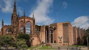 a large brick building with a tower and a church at Cosy Family Home - Coventry City Centre - Entire House in Coventry