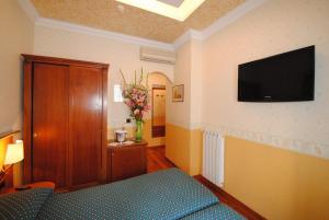Televízia a/alebo spoločenská miestnosť v ubytovaní Hotel Verona Rome