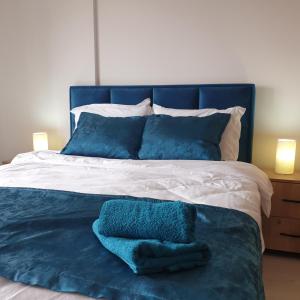a blue and white bed with two towels on it at Milmari apartman N67 MAVI in Kopaonik