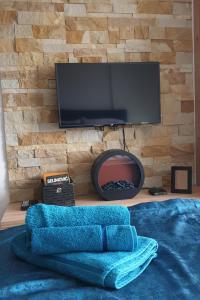 a living room with a tv and a blue blanket at Milmari apartman N67 MAVI in Kopaonik
