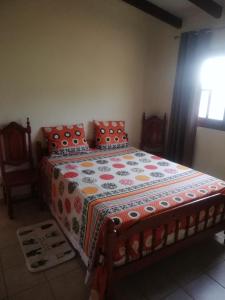 a bedroom with a bed with a quilt on it at Appartement avec vue sur mer in Bouillante