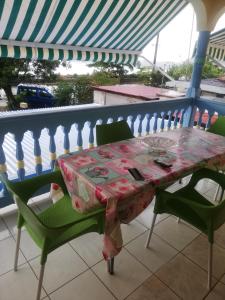 een tafel en 2 stoelen op een balkon bij Appartement avec vue sur mer in Bouillante