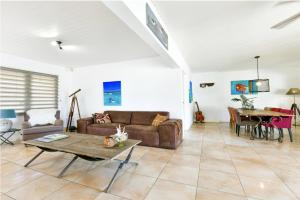una sala de estar con un sofá y una mesa en Sunny Palm Beach Villa, en Palm-Eagle Beach