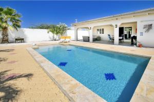 Sunny Palm Beach Villa في شاطئ بالم إيغل: مسبح في الحديقة الخلفية للمنزل