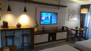 uma sala de estar com uma televisão na parede em Buzios Beach Resort Apartamento Luxo Home Premium em Búzios