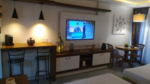 ein Wohnzimmer mit einem TV an der Wand in der Unterkunft Buzios Beach Resort Apartamento Luxo Home Premium in Búzios