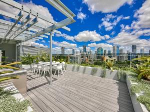 a deck with a table and chairs on top of a building at Lovely 2 Bedroom Executive Apartment in Brisbane