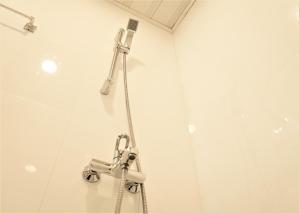 a shower in a bathroom with a shower head at Nala Island Village in Maafushi