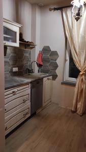 a kitchen with a counter and a sink and a window at Stare Dechy in Wschowa