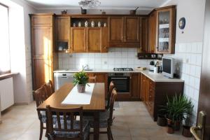 a kitchen with wooden cabinets and a table with chairs at la casa nel prunent in Trontano