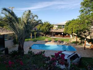 um quintal com uma piscina e uma palmeira em Pousada Recanto Das Emerências em Búzios