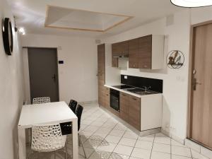a kitchen with a table and some chairs and a table and a counter at Au Petit Bonheur Malouin in Malo-les-Bains