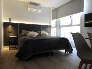 a bedroom with a bed with a black headboard at Residencias Roque Suarez in Mar del Plata