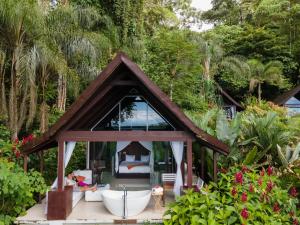 a small house with a tub in a garden at Oxygen Jungle Villas & Spa in Uvita