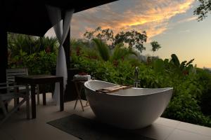 a bath tub sitting in front of a garden at Oxygen Jungle Villas & Spa in Uvita