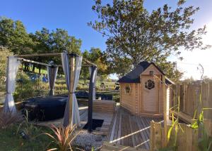 eine Holzterrasse mit einem Pavillon und einem Hundehaus in der Unterkunft Chez Flo et Marc in Chouzy-sur-Cisse