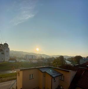 einen Blick auf eine Stadt mit der Sonne am Himmel in der Unterkunft Apartman 2411 in Valjevo